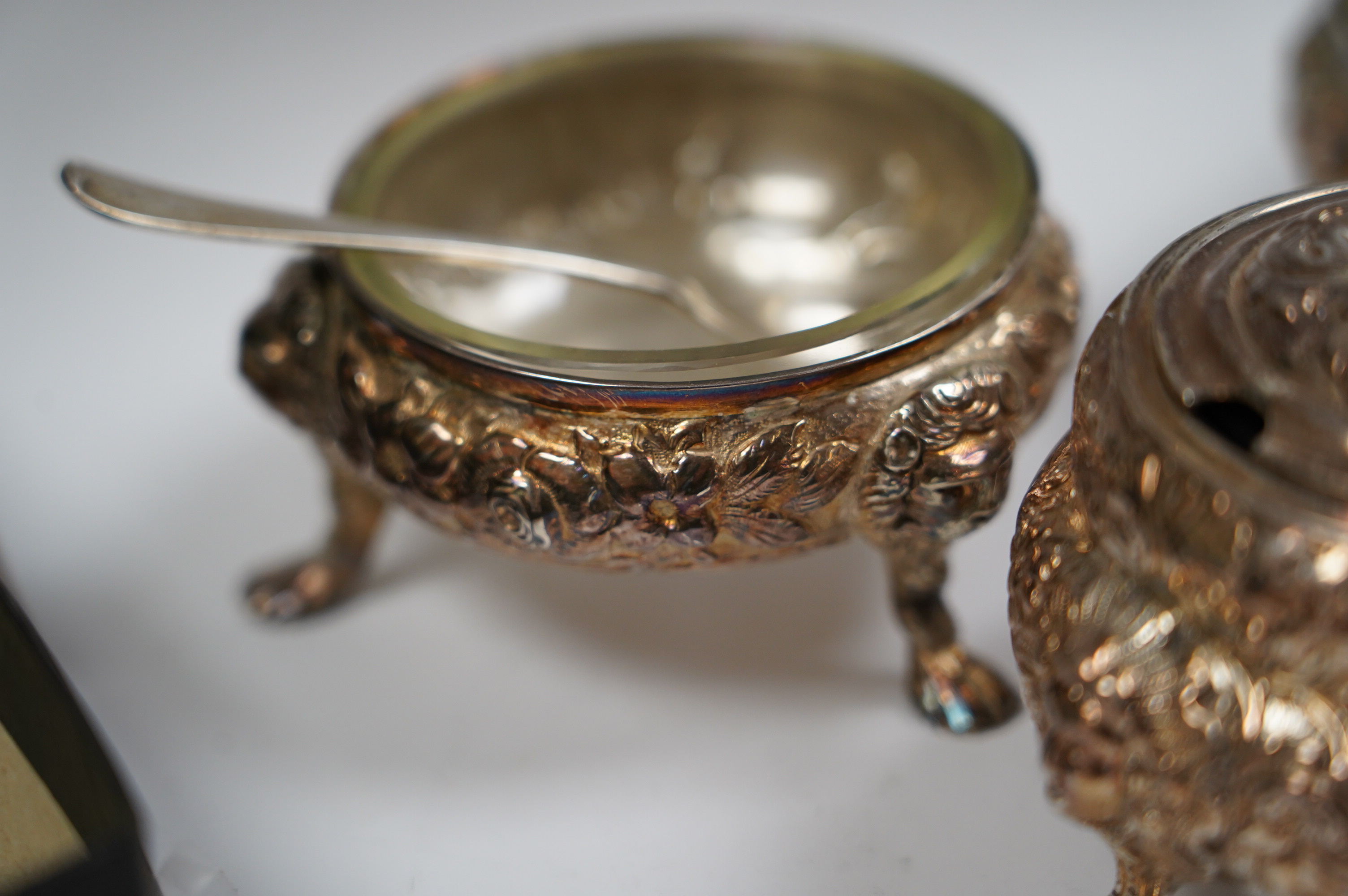 A Georgian Scottish silver mustard pot, width 9cm, marks rubbed, and a pair of similar Irish? silver cauldron salts and two associated later spoons. Condition - poor to fair